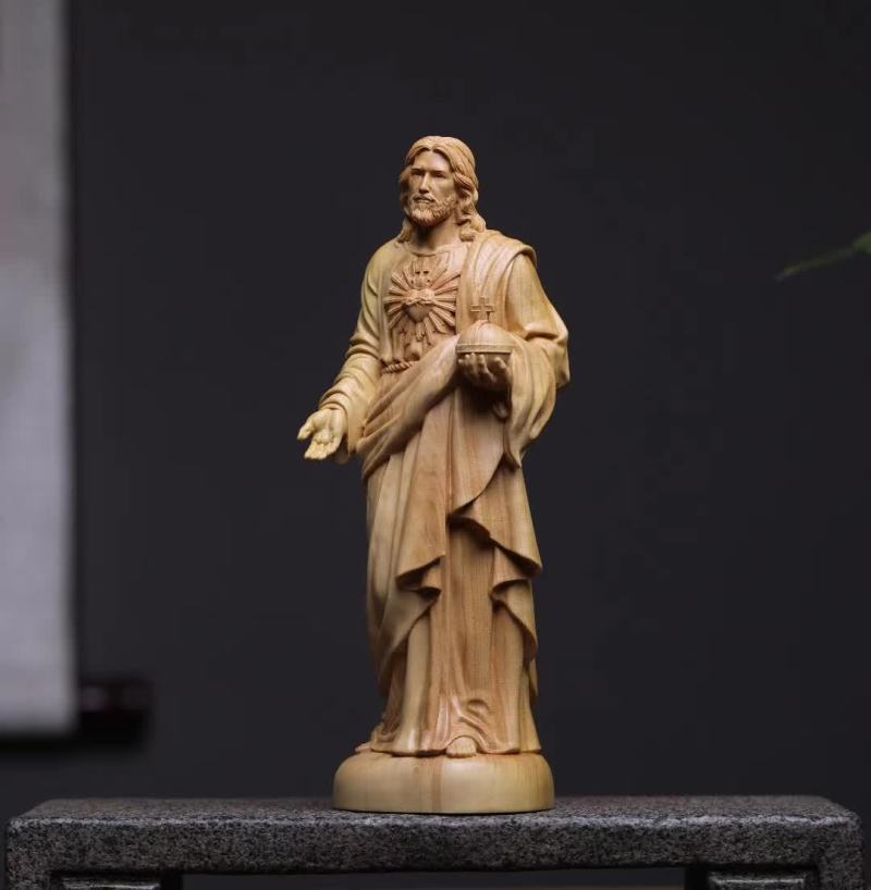 Wooden statue of a religious figure on a dark background