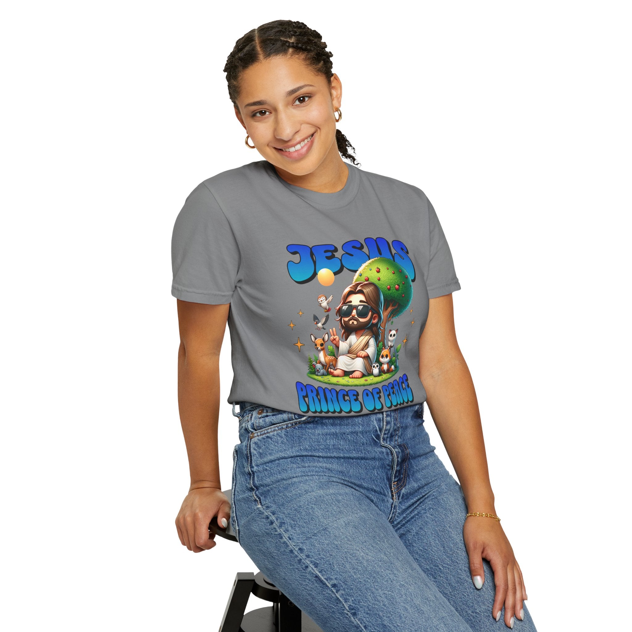 Person wearing a gray t-shirt with a colorful graphic design sitting on a stool.