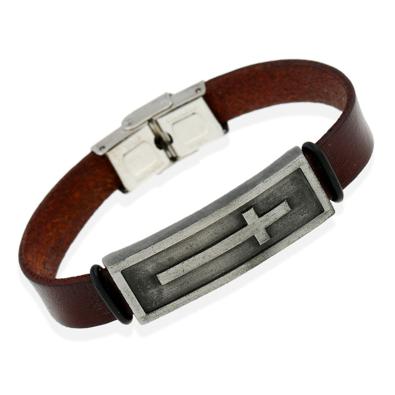 Brown leather bracelet with a metal clasp and cross emblem on a white background