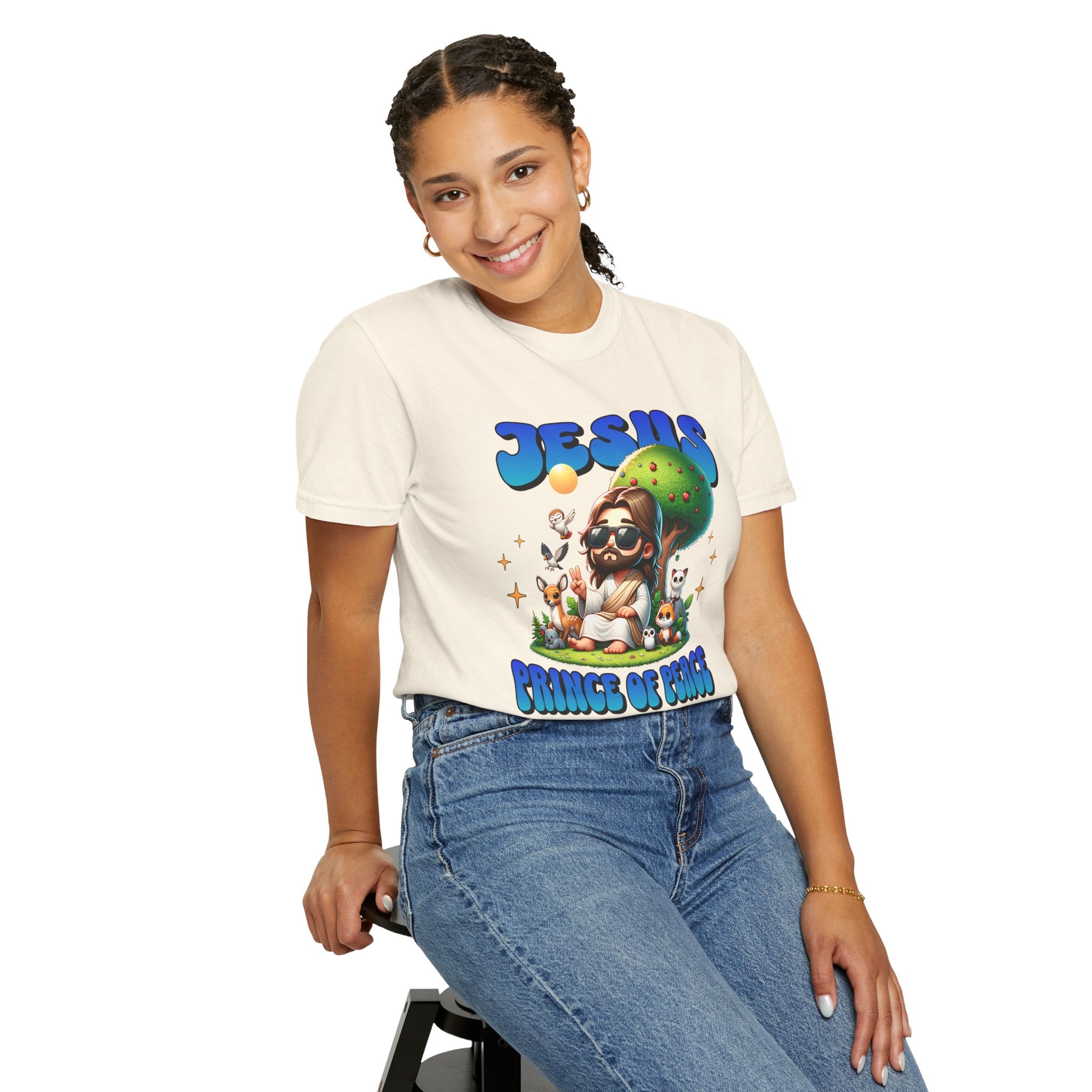 Person wearing a white t-shirt with colorful graphics and text, sitting on a stool against a white background.