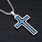 Cross-shaped pendant with blue inlay on a black textured background