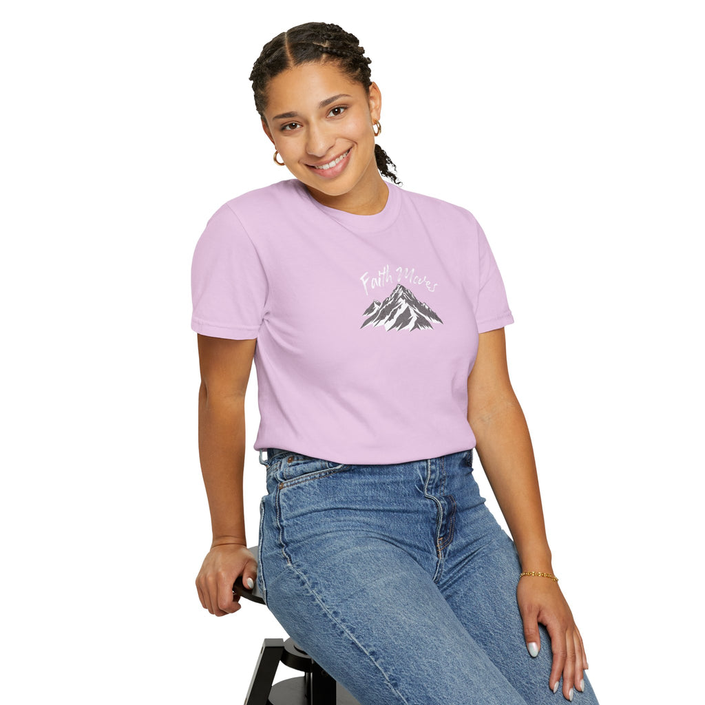 Person wearing a purple t-shirt with a mountain graphic and text, sitting on a stool against a white background.