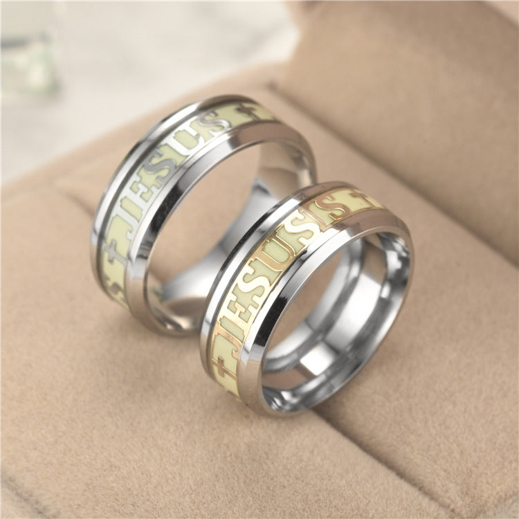 Two rings with 'Jesus' engraving on a beige surface