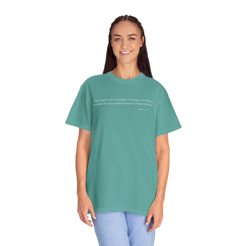 Woman wearing a teal t-shirt with a graphic design on a white background