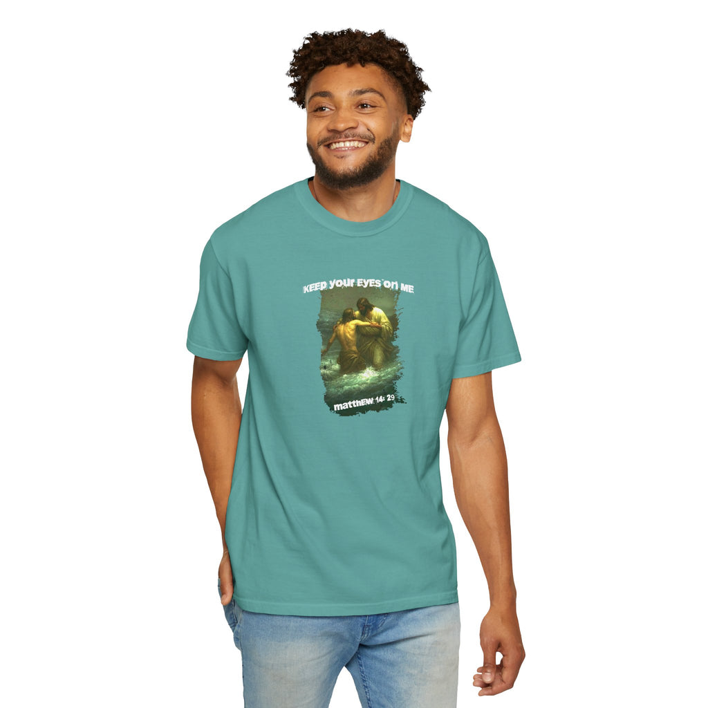 Man wearing a teal t-shirt with a graphic design on a white background