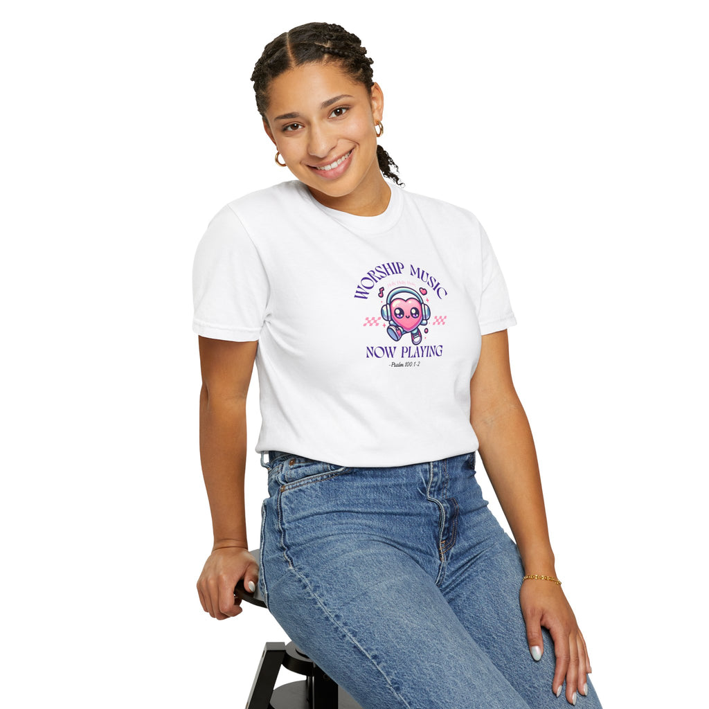 Person wearing a white t-shirt with a graphic design and text, sitting on a stool against a white background.