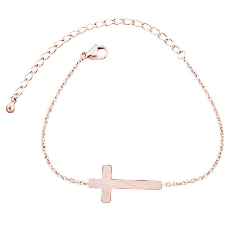 Rose gold bracelet with a cross pendant on a white background