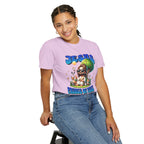 Person wearing a purple t-shirt with a graphic design sitting on a stool against a white background