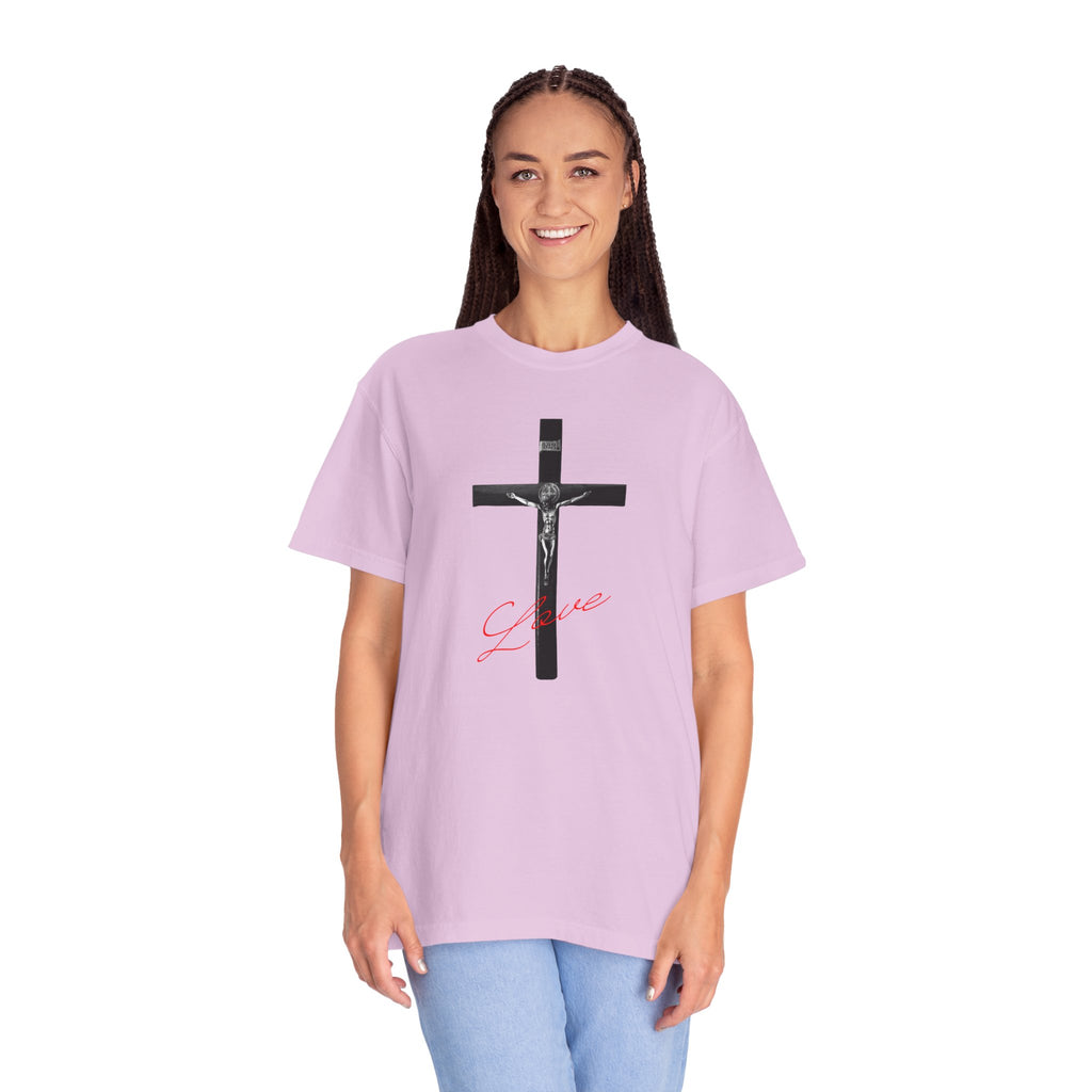 Person wearing a light purple t-shirt with a black cross design and pink text on a white background