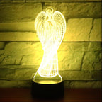 Angel-shaped lamp with a warm glow against a stone wall background