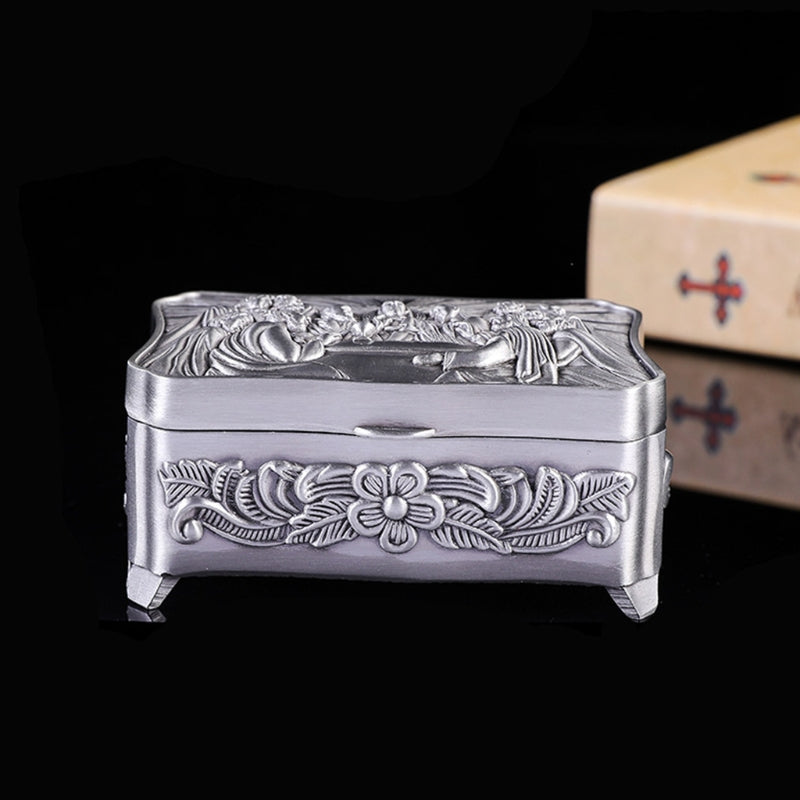 Decorative silver box with floral embossing on a black background