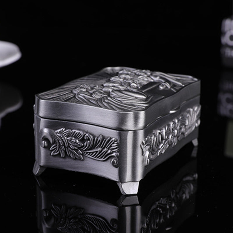 Decorative silver box with intricate designs on a black background