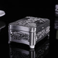 Decorative silver box with intricate designs on a black background