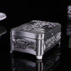 Decorative silver box with intricate designs on a black background