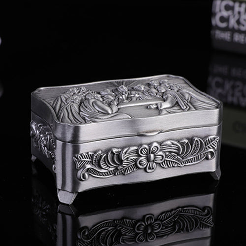 Decorative silver box with floral patterns on a black background