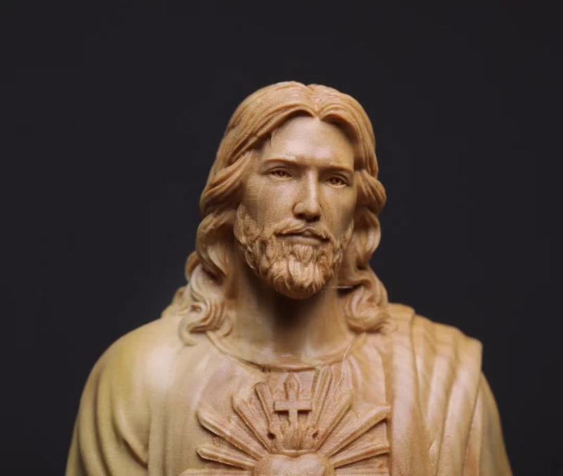 Statue of a religious figure with long hair and beard on a black background