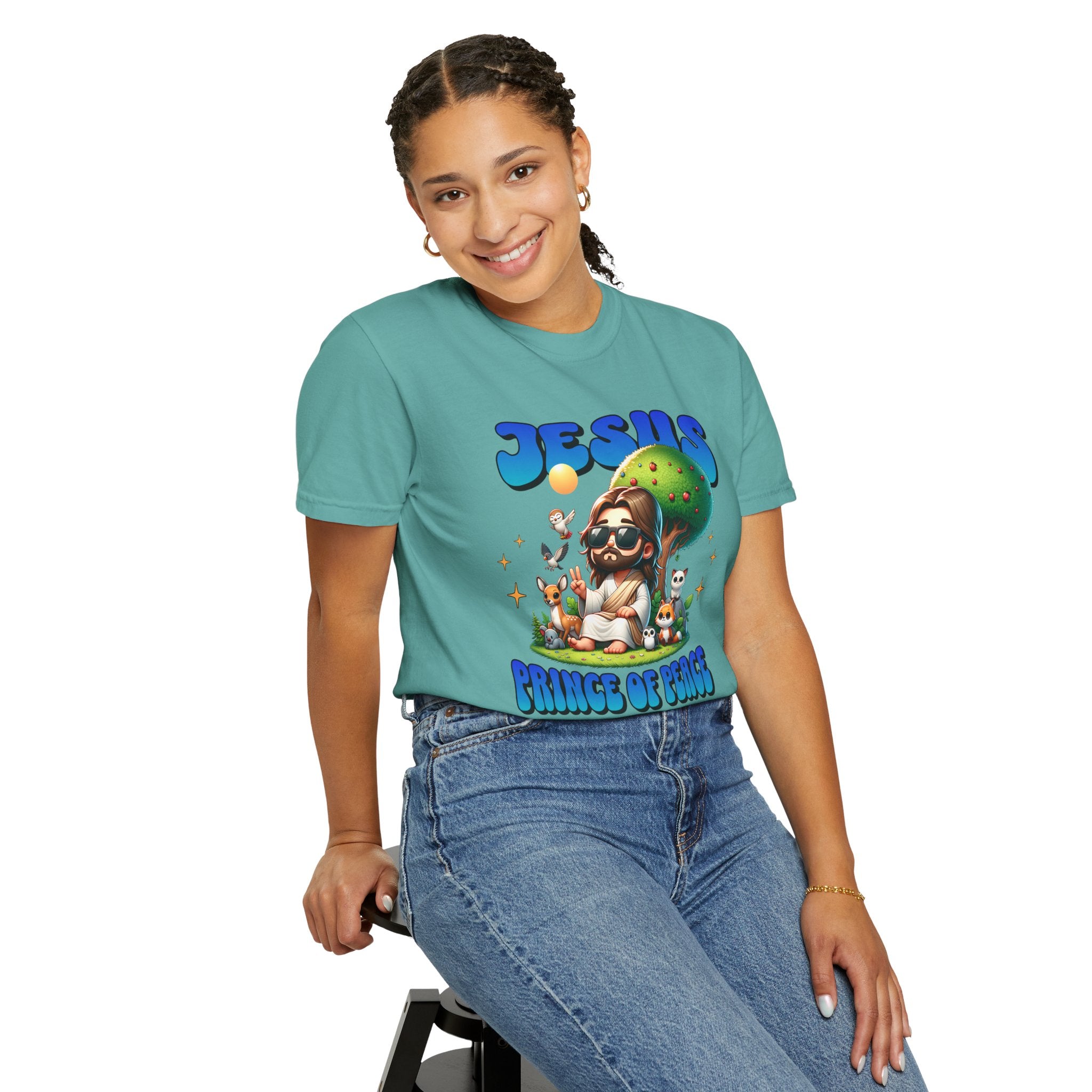 Person wearing a teal t-shirt with a graphic design sitting on a stool.