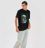Person wearing a black t-shirt with a graphic design and light blue jeans on a white background