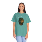 Person wearing a teal t-shirt with a graphic design and text on a white background