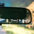 Car rearview mirror with 'Trust in God' text and heart symbol
