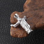 Silver angel pendant on a textured brown rock with a dark background