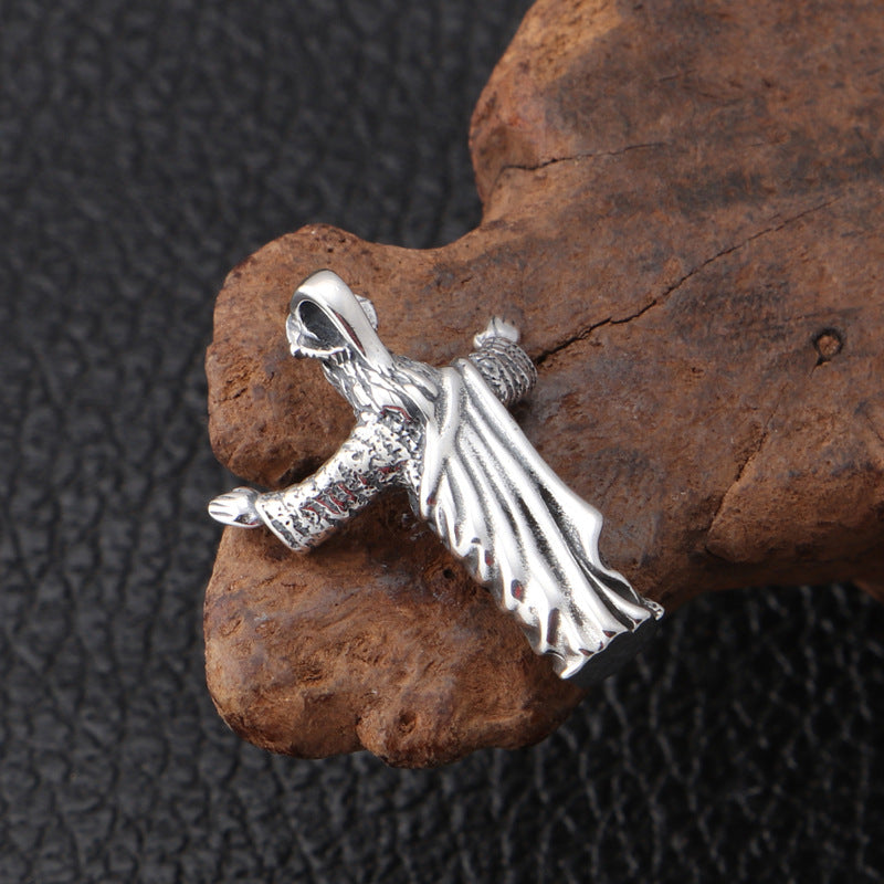 Silver angel pendant on a textured brown rock with a dark background