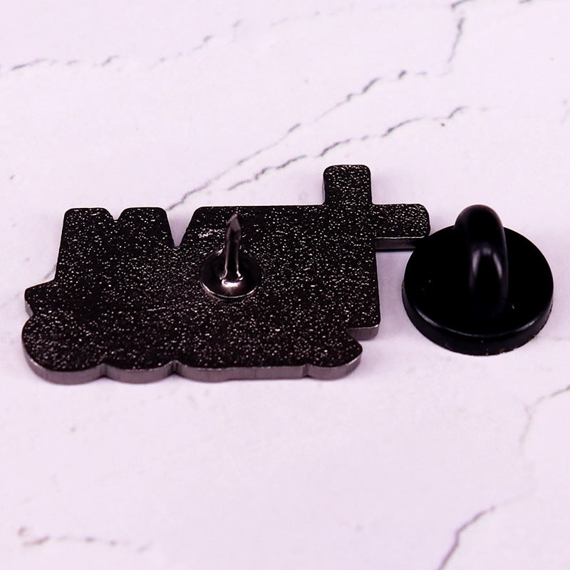 Black glittery 'MAD' pin on a white marble background