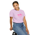 Person wearing a pink t-shirt with text and blue jeans on a white background
