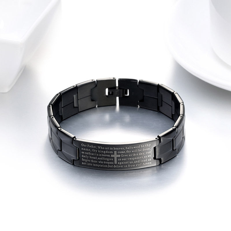 Black metal bracelet with engraved text on a white background