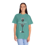 Person wearing a teal t-shirt with a graphic design on a white background