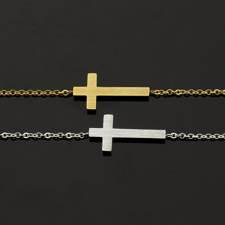 Two gold and silver cross necklaces on a black background
