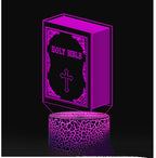 Purple LED night light shaped like a Bible with a cross on a black background