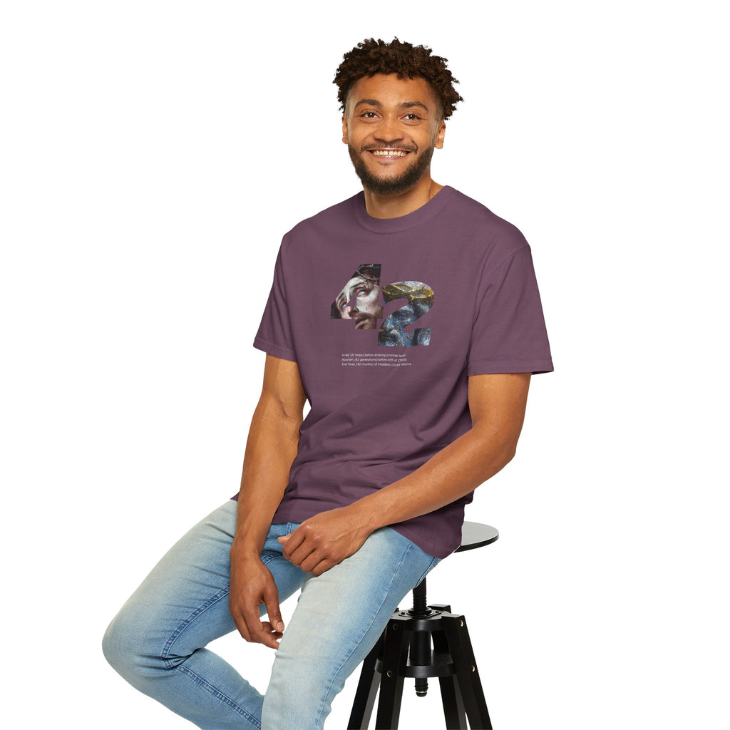 Man sitting on a stool wearing a purple t-shirt with a logo, on a white background