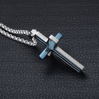 Metallic cross pendant on a chain against a dark textured background