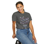 Woman wearing a gray t-shirt with colorful text and blue jeans on a white background