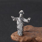 Silver figurine of a deity on a dark background