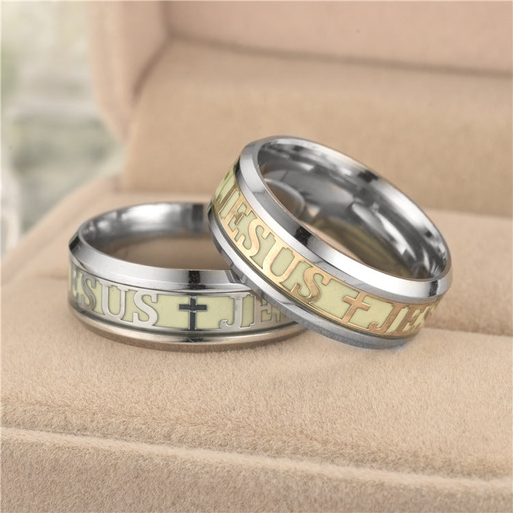 Two rings with 'Jesus' engraving on a beige surface