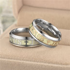Two rings with 'Jesus' engraving on a beige surface