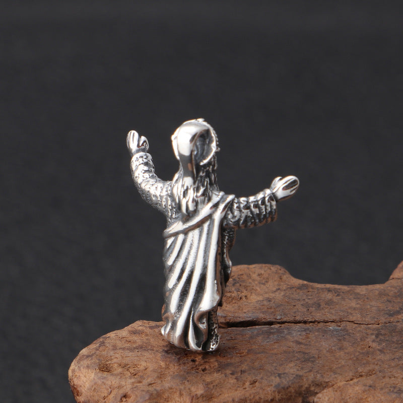 Silver pendant of a hooded figure on a dark background