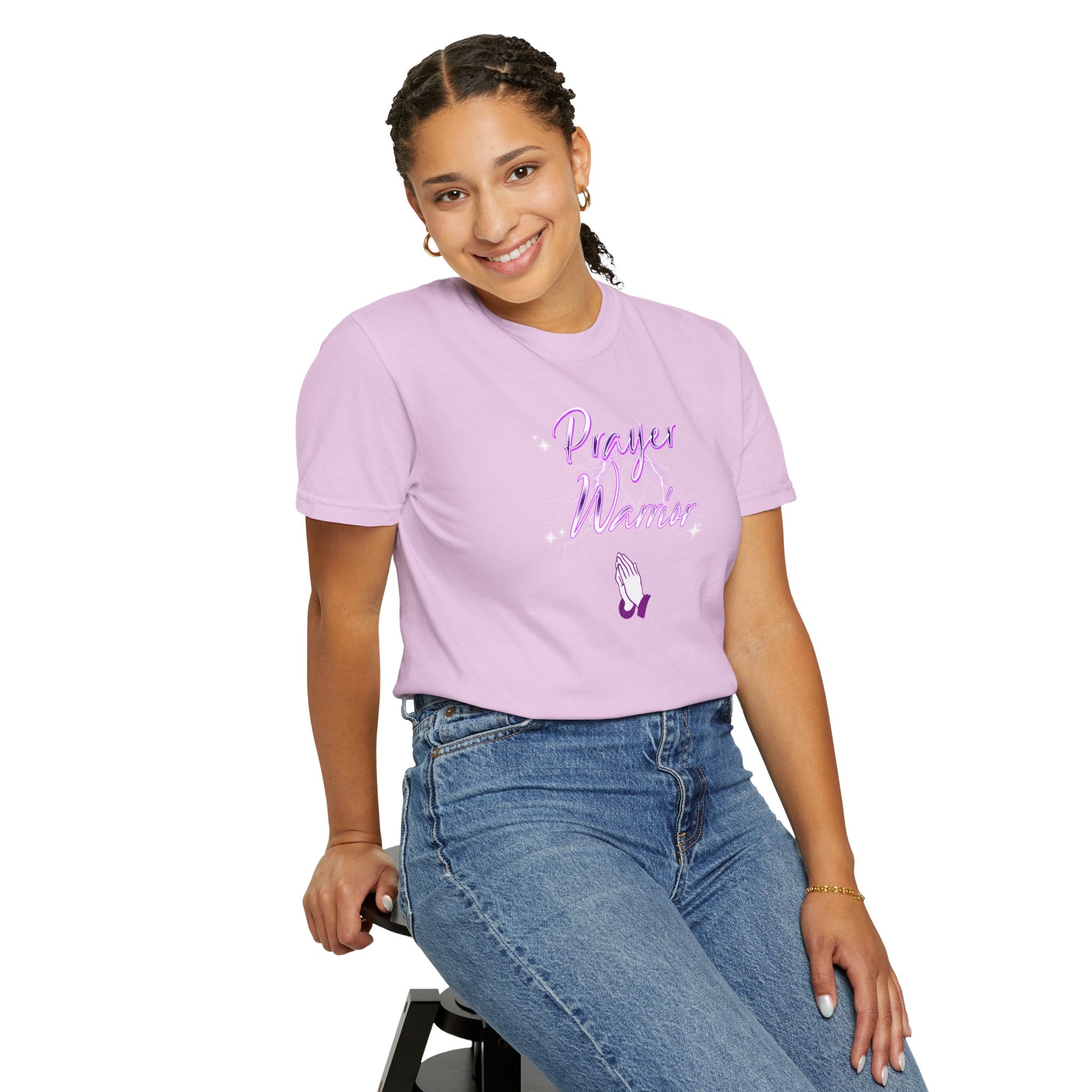 Person wearing a purple t-shirt with text and graphics, sitting on a stool against a white background