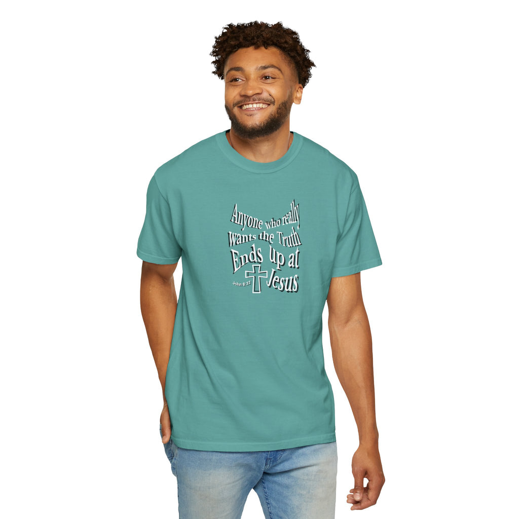 Man wearing a teal t-shirt with text and a cross graphic on a white background