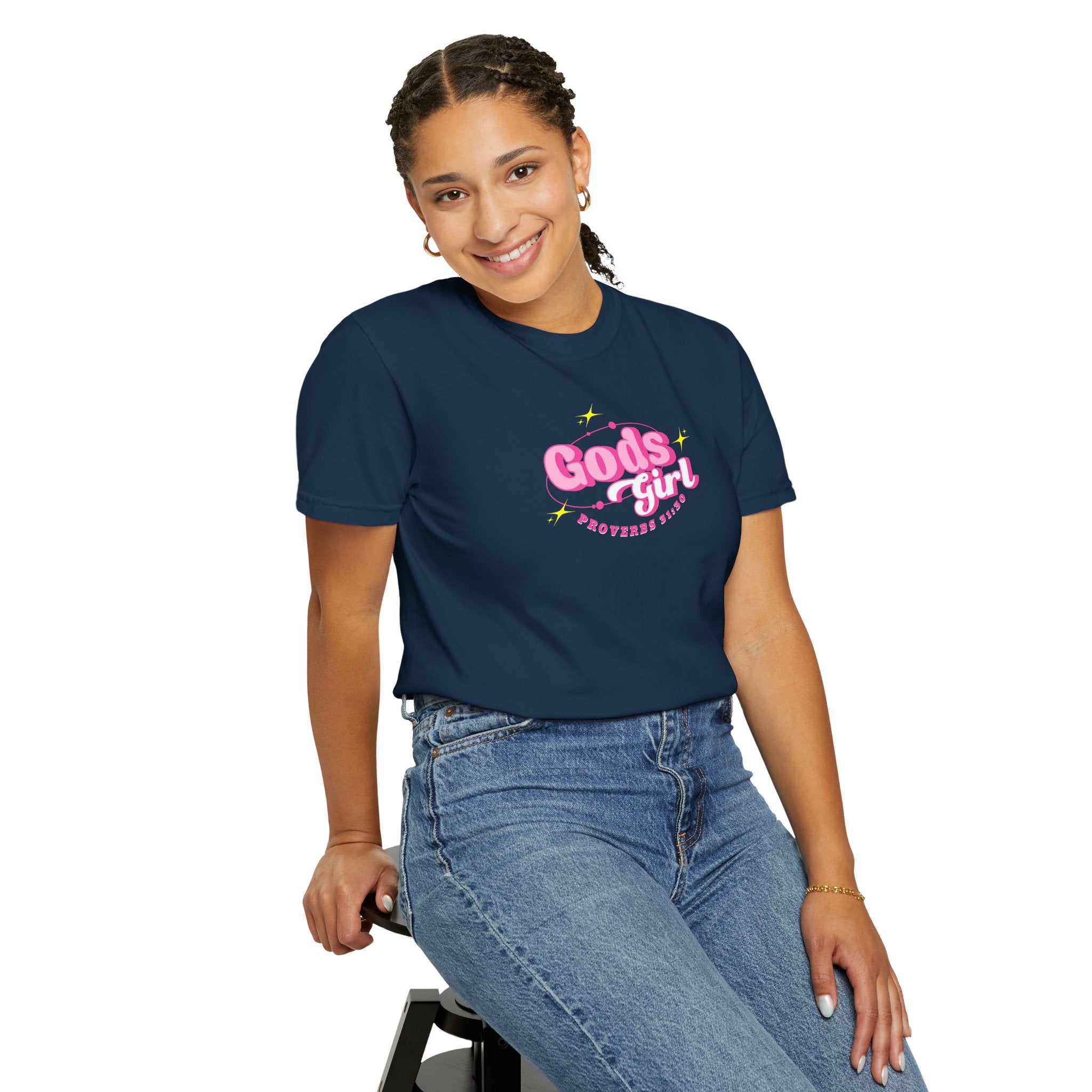 Person wearing a navy blue t-shirt with 'Gods girl' text, sitting on a stool against a white background