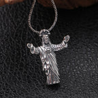 Silver Jesus pendant on a chain against a dark textured background