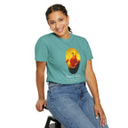 Person wearing a teal t-shirt with a graphic design on a white background