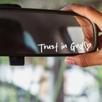 Hand holding a car rearview mirror with 'Trust in God' text