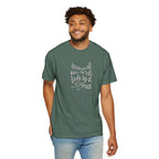 Man wearing a green t-shirt with text and a cross graphic on a white background