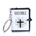 Keychain with a miniature Bible design featuring a cross on a white background