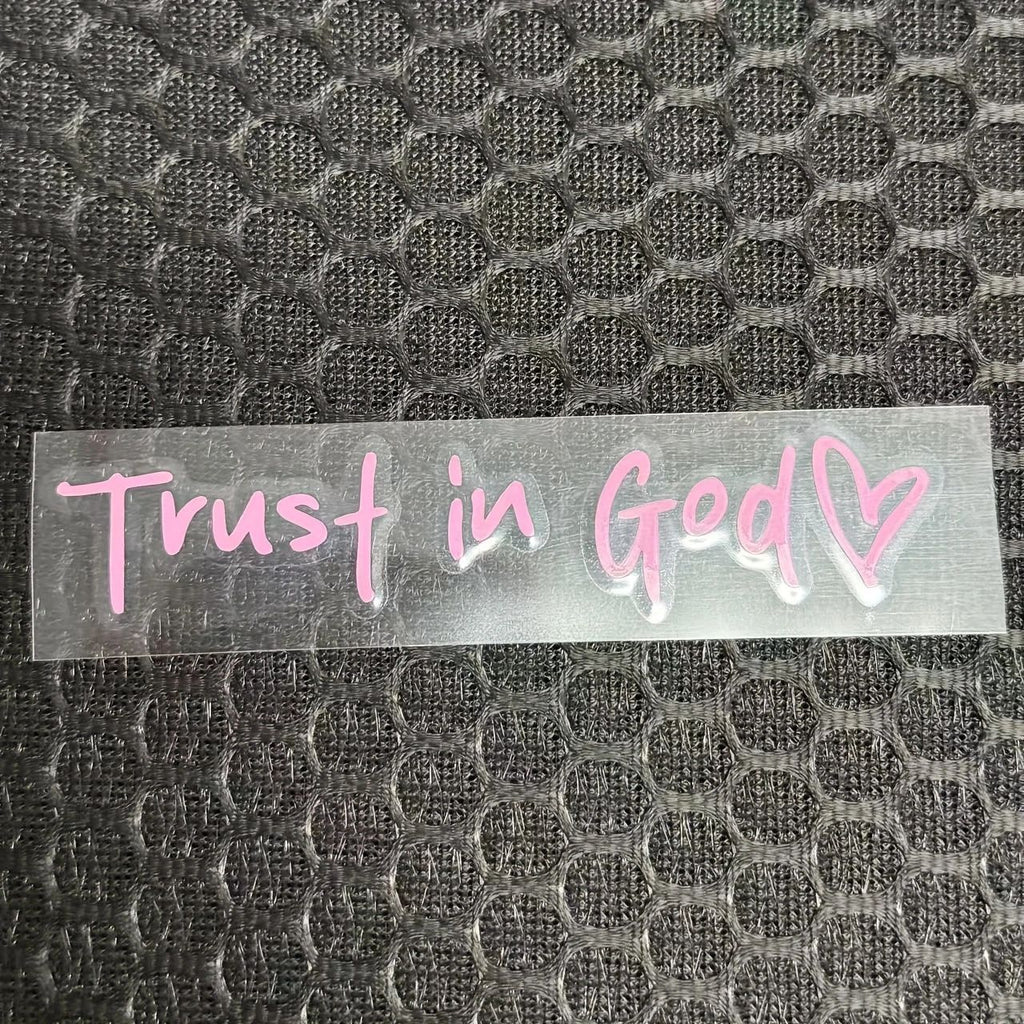 Clear decal with 'Trust in God' text on a textured black background