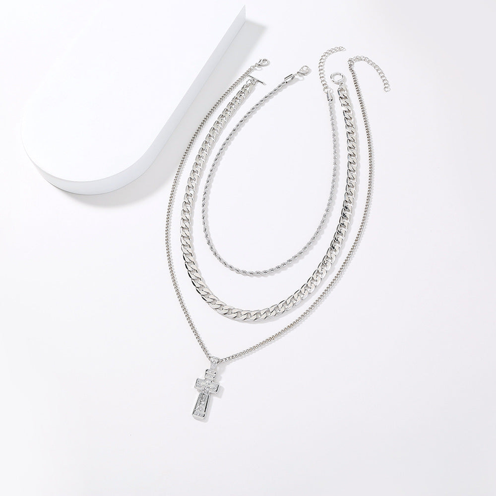 Set of silver chain necklaces with a cross pendant on a white background