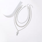 Set of silver chain necklaces with a cross pendant on a white background